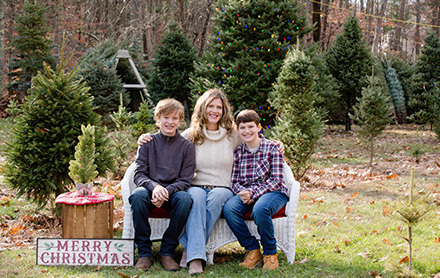 Two sons posing with their mother in a holiday photoshoot directed by Eileen Nelson Photography.