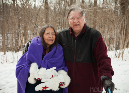 Elders Dan Smoke and Mary Lou Smoke post together in the snowy woods