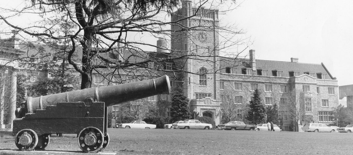 Black and white photo of cannon in front of Johnston Hall