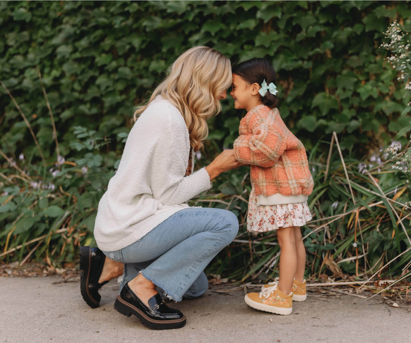An image of a woman and a little girl affectionately kissing