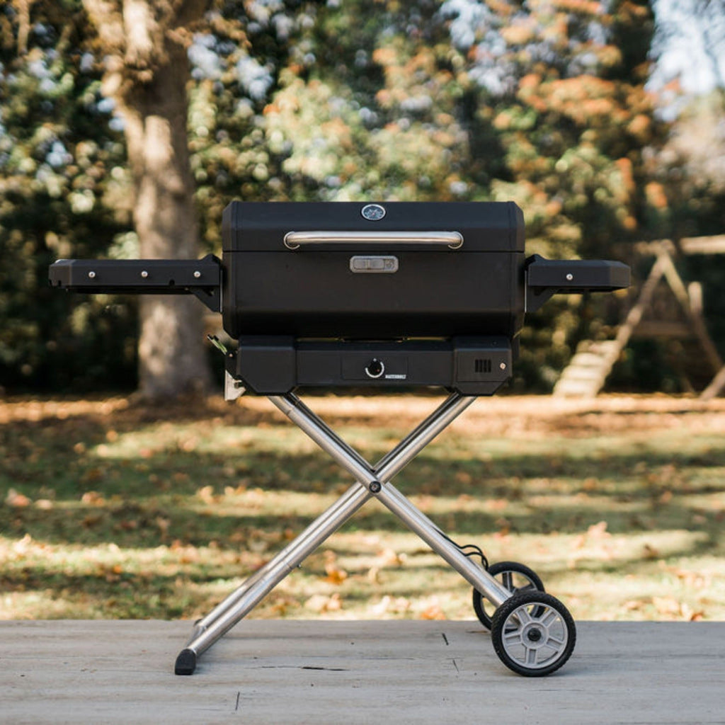 Portable Charcoal BBQ and Smoker on QuickCollapse Cart with side shelves. Left shelf is about twice as wide as the right shelf. Cart has wheels on the right .