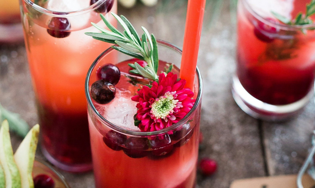 Holiday punch bowl filled with cranberry sweet tea, floating cranberries, and rosemary sprigs