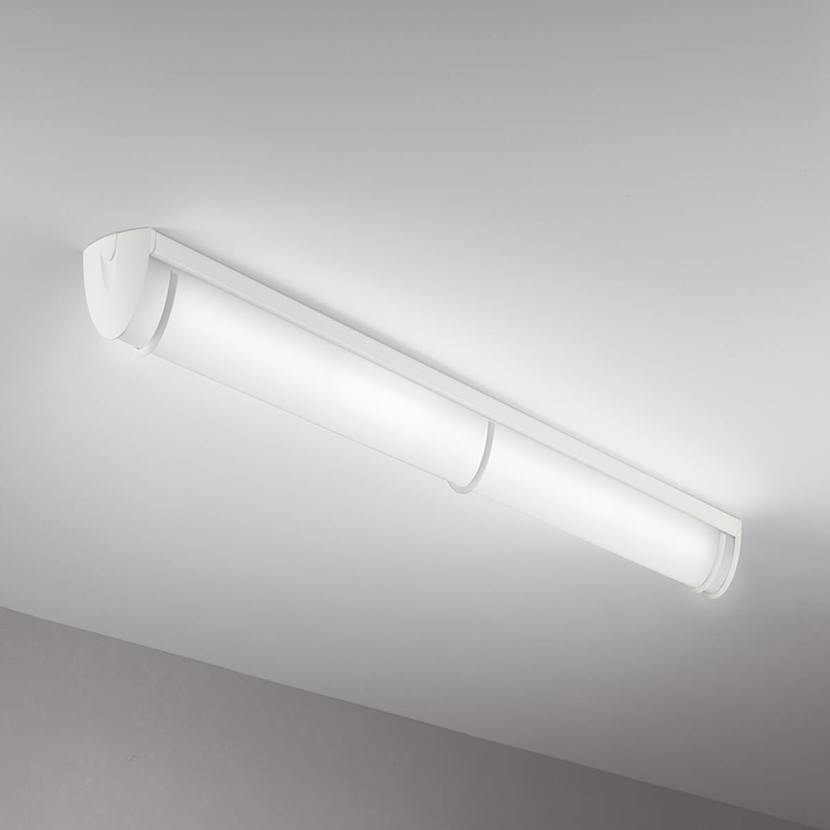 A luminous surface-mounted luminaire with a curved linear diffuser body and trim accents