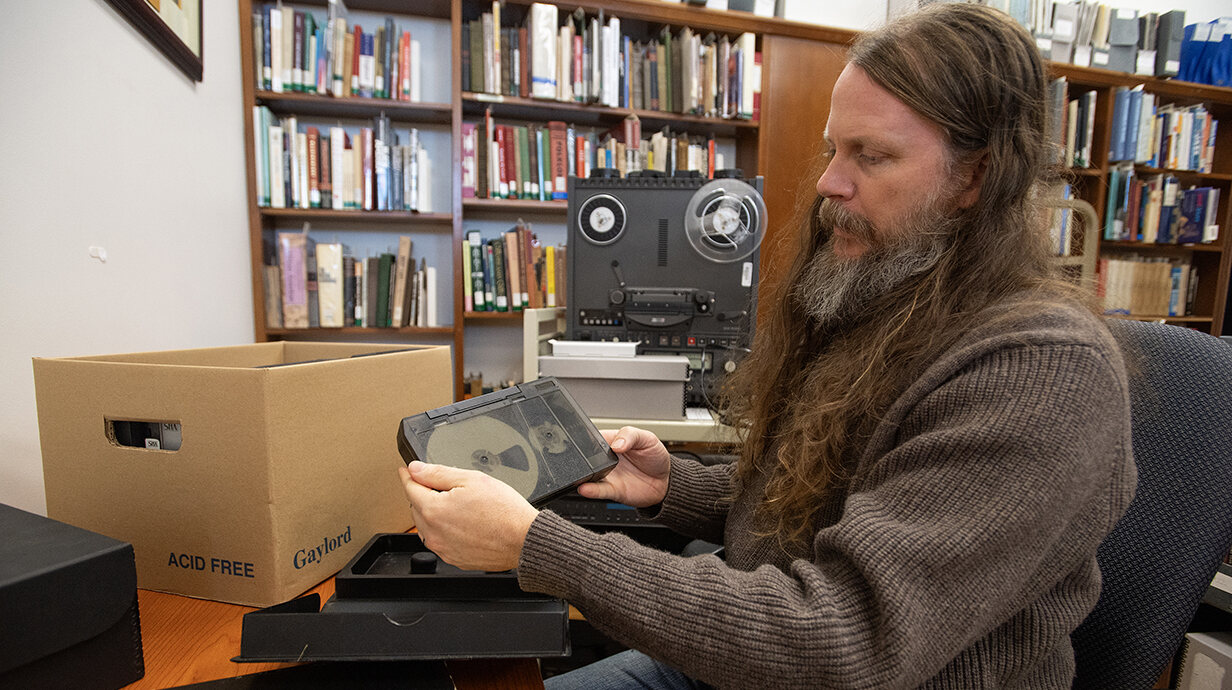 Greg Johnson, head of the Department of Archives and Special Collections, examines a videotape to be digitized as part of a project to make the archive's materials more accessible to researchers and the public. Photo by Thomas Graning/Ole Miss Digital Imaging Services