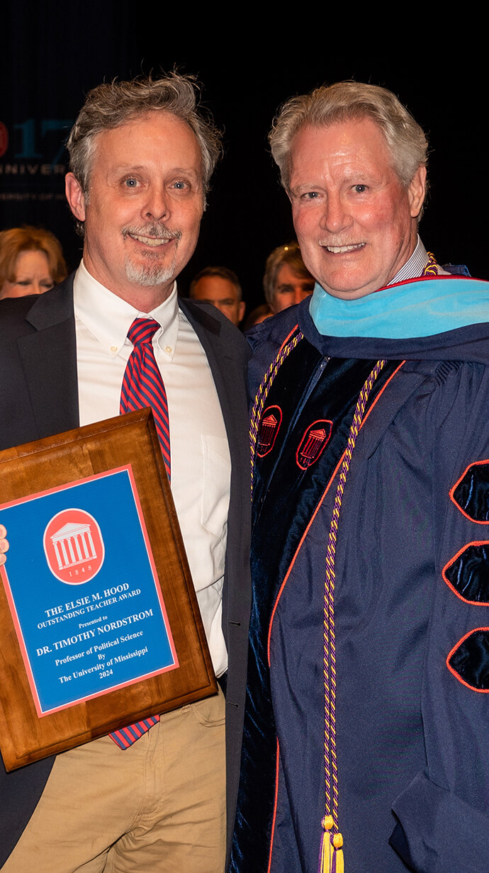 Chancellor Glenn Boyce (right) presents Timothy Nordstrom with the 2024 Elsie M. Hood Outstanding Teacher of the Year award at the annual Honors Day Convocation. Photo by Bill Dabney/UM Foundation
