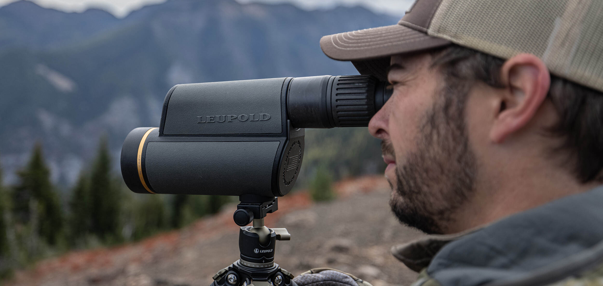 hunter wearing camouflage and hat glassing with leupold spotter scope