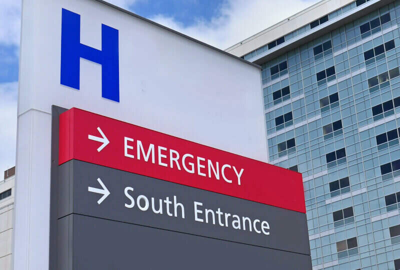 A hospital sign directing visitors to either the emergency department or the south entrance.