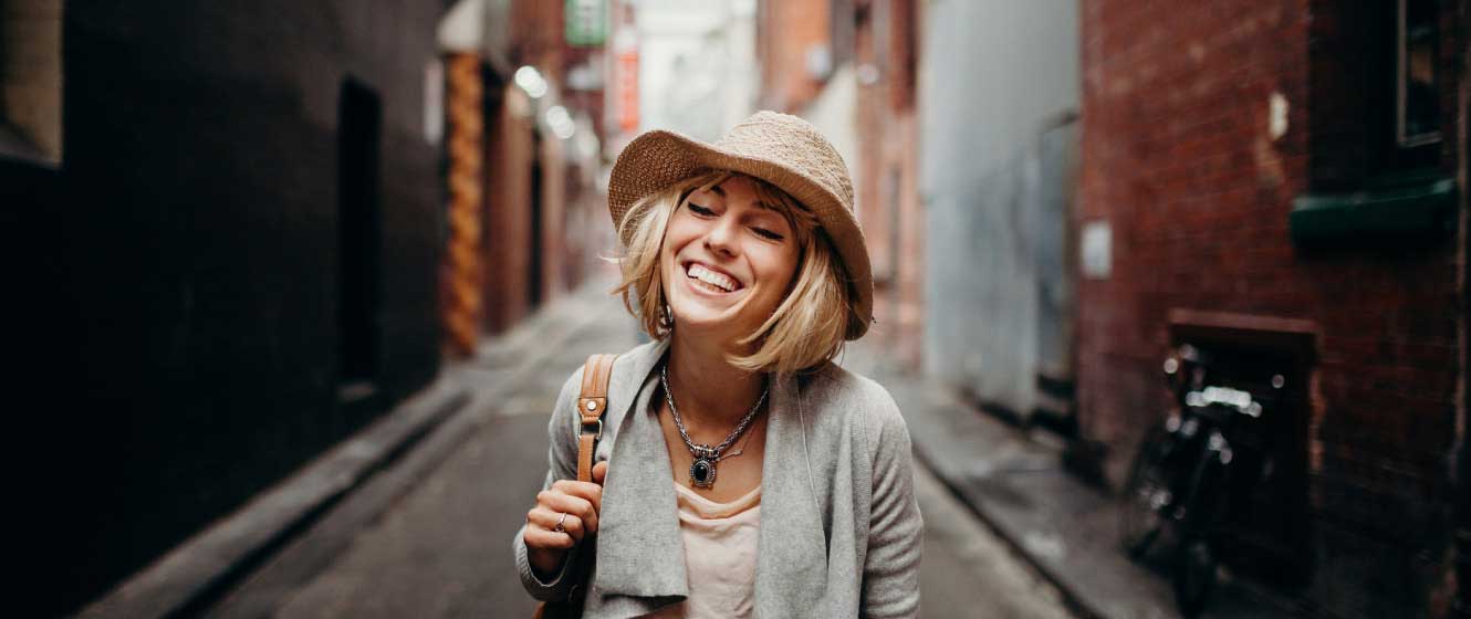 Woman smiling while walking down a city street