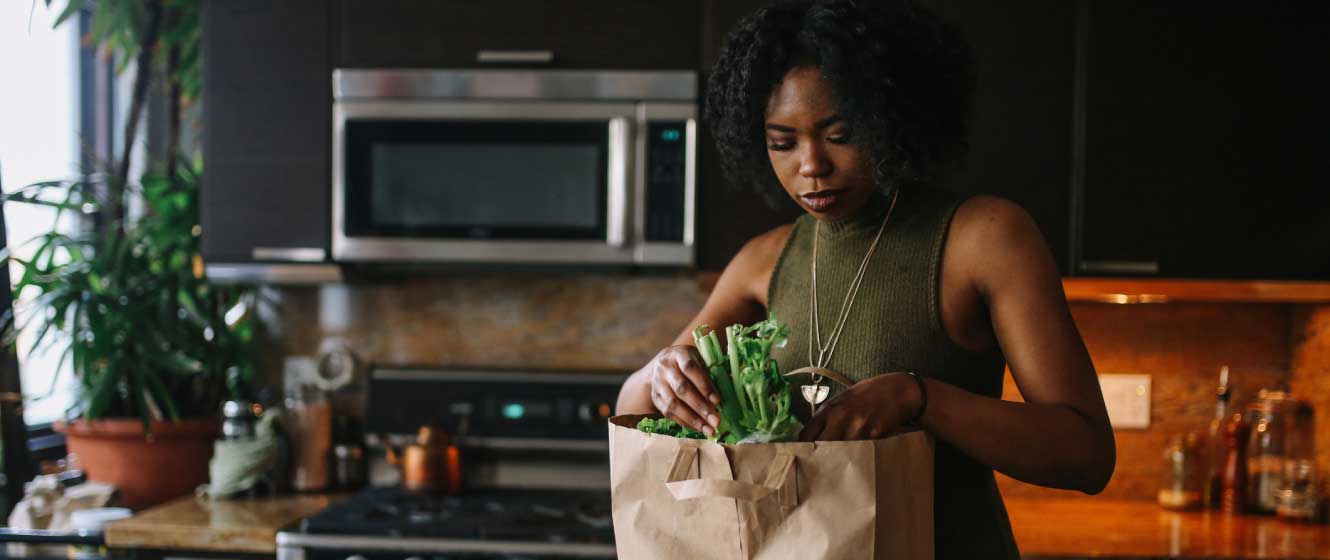 Woman unloading groceries in her kitchen