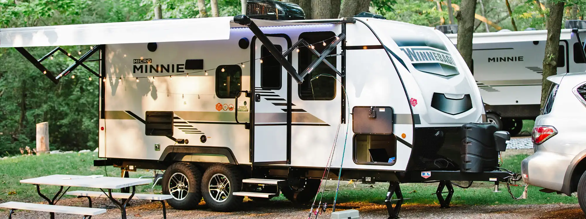 winnebago micro minnie travel trailer set up at a campsite