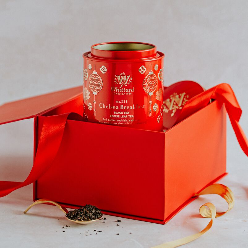 Chinese New Year Gift Set with caddy rising out of box and loose tea next to gift box