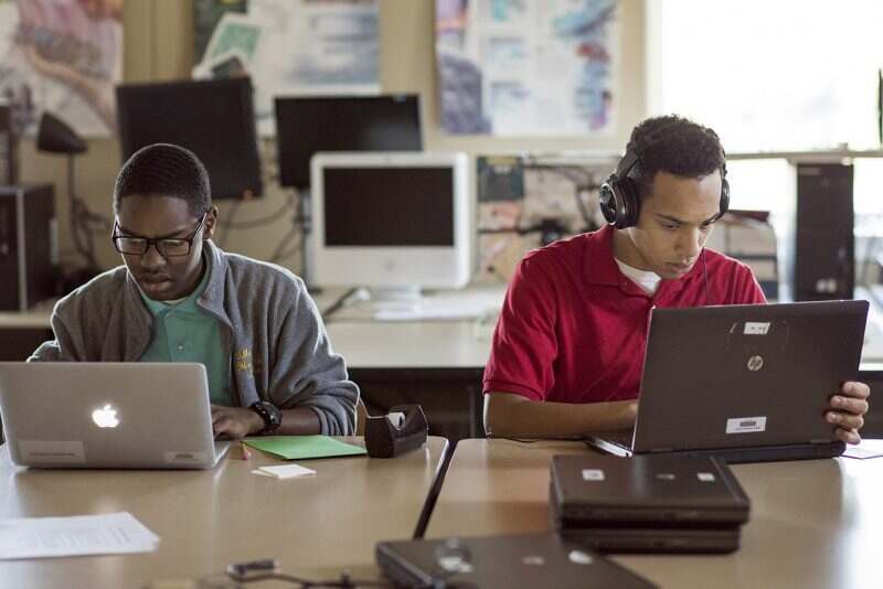 Two Milton Hershey School students work on their laptops during a computer science class.