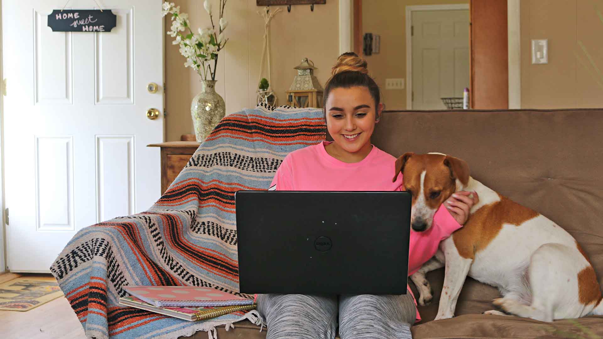 Student on laptop with pet dog
