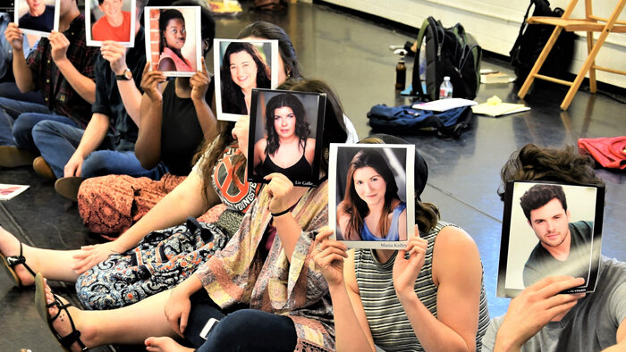 Photo of acting students holding headshots in front of their faces