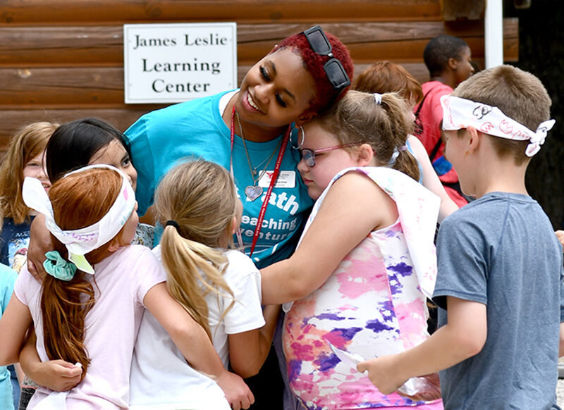 A Flight Path to Teaching participant gets hugs from campers.