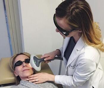 A female patient undergoing intense pulse light treatment on her face.