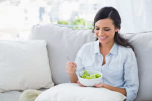 Woman with salad bowl and fork in her hands