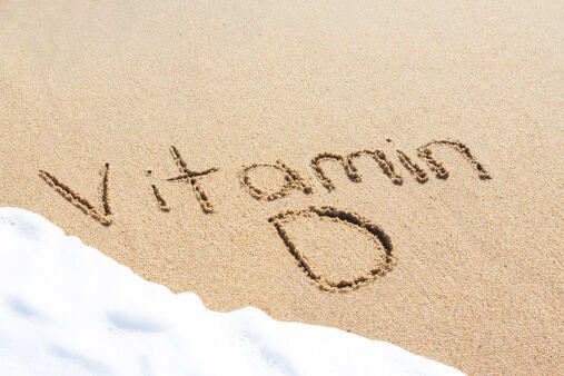 Picture of a sandy beach with Vitamin D written in sand