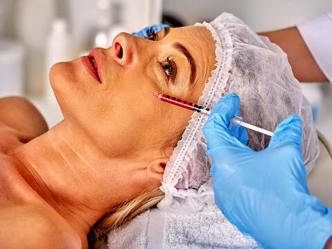 Middle aged woman getting botox on her face below her eyes