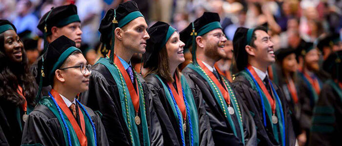 A group of JSSOM graduates standing together at graduation