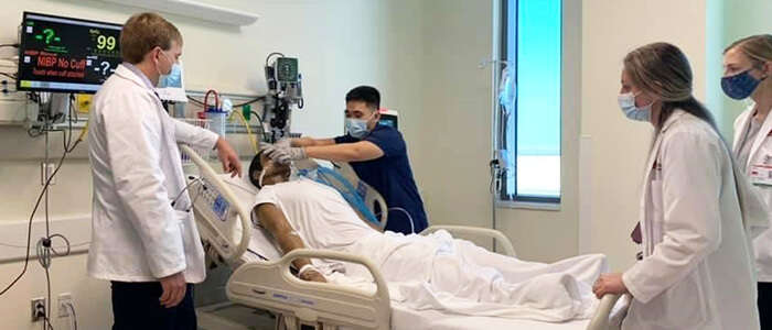 PAS students standing around a simulation dummy