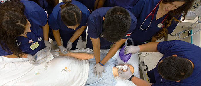 SHP students gathered around medical dummy performing CPR