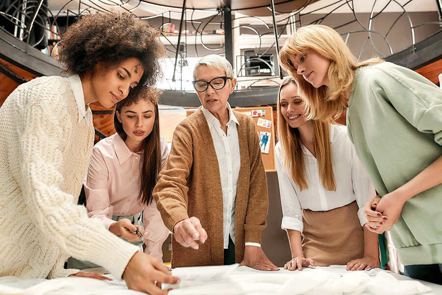 group of women of all ages collaborating at a work table