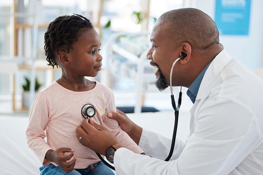 A doctor listening to a child's heart with a stethoscope