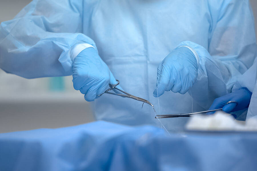 Close up of a surgeon sewing up a patient's incision