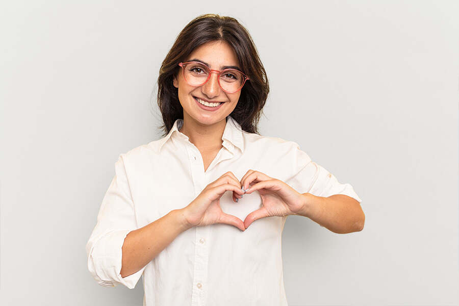 A woman hold up her hands in the shape of a heart