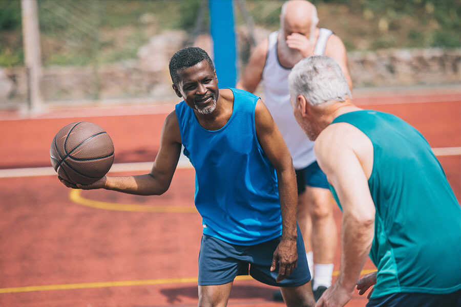 Two middle aged men playing basketball