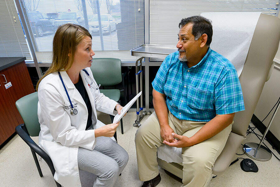 Dr. Raimer speaking with a male patient